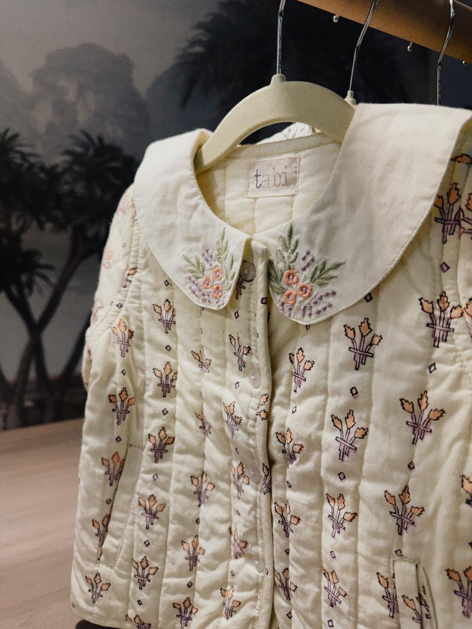 Embroidered jacket on a hanger with a blurred background