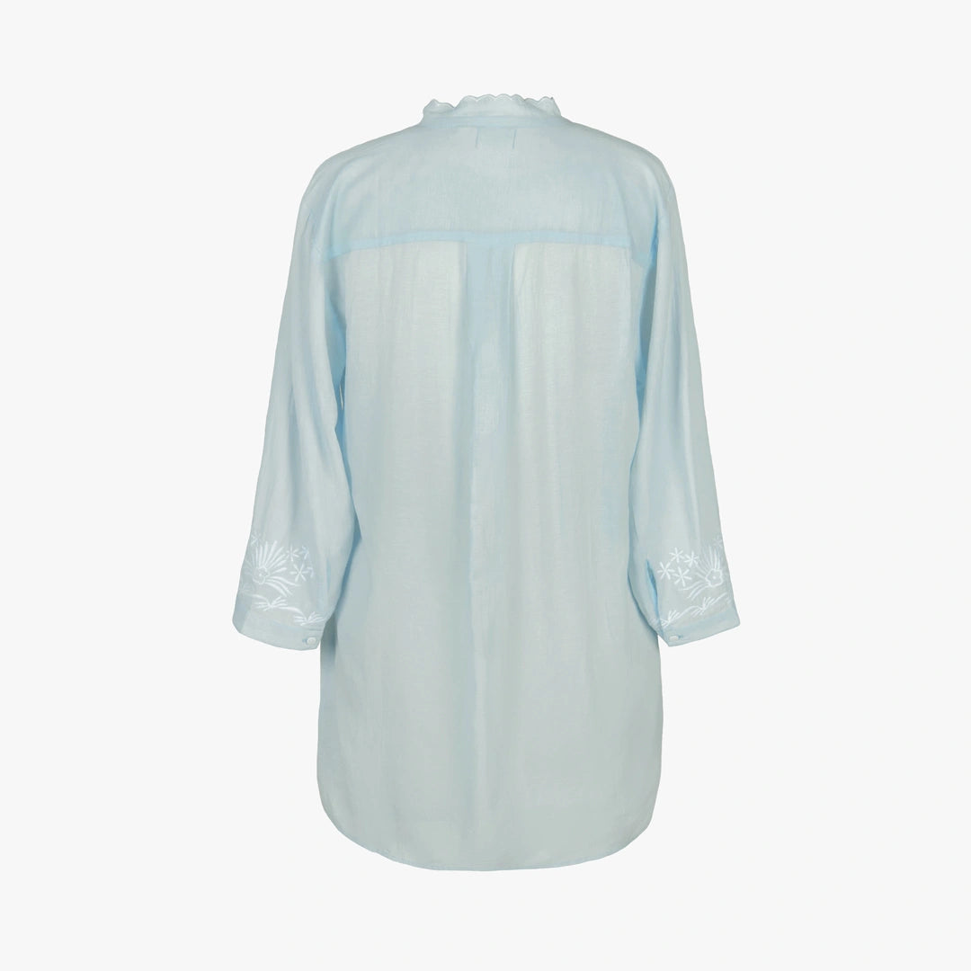 A light blue long-sleeve button-up shirt shown from the back, featuring subtle white floral embroidery on the cuffs and a matching light blue collar, set against a plain white background.