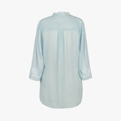 A light blue long-sleeve button-up shirt shown from the back, featuring subtle white floral embroidery on the cuffs and a matching light blue collar, set against a plain white background.