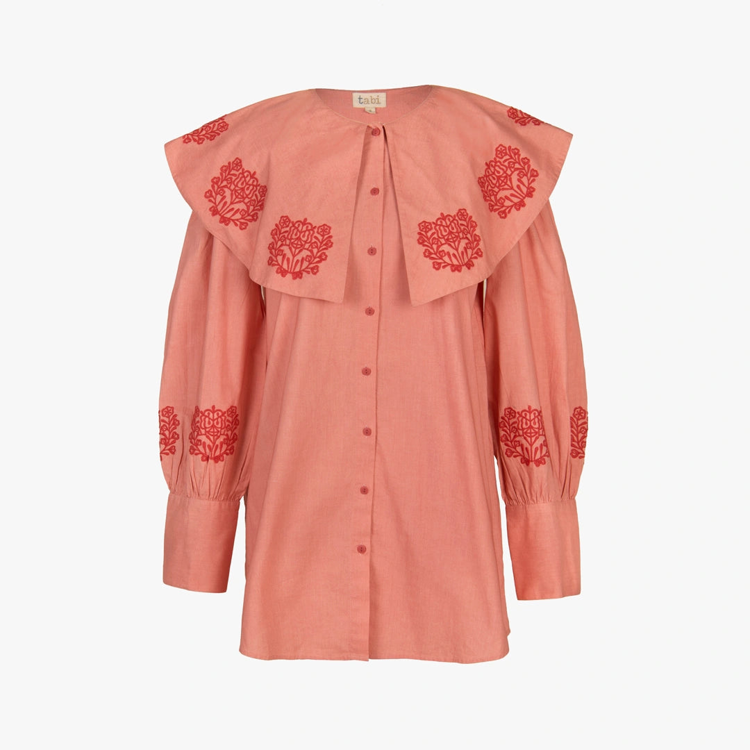 A dusty pink long-sleeve blouse with a large layered ruffled collar and red embroidered floral motifs, shown against a plain white background.