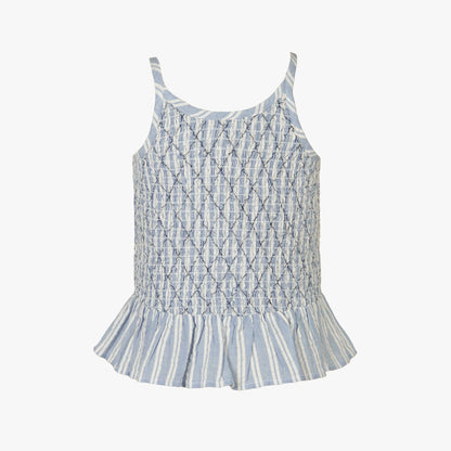 A sleeveless baby top with a smocked bodice and ruffled hem, featuring a light blue and white monogram pattern and vertical stripes on the skirt, shown against a plain white background.