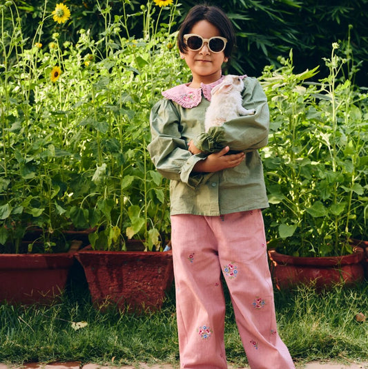 Child holding a rabbit in a garden setting