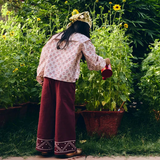 Person watering plants in a garden