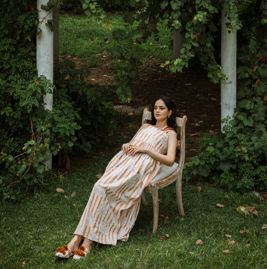 Woman in a striped dress sitting on a chair in a garden setting