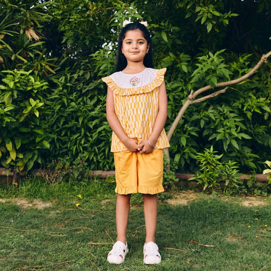 Young girl in a yellow outfit standing in a garden
