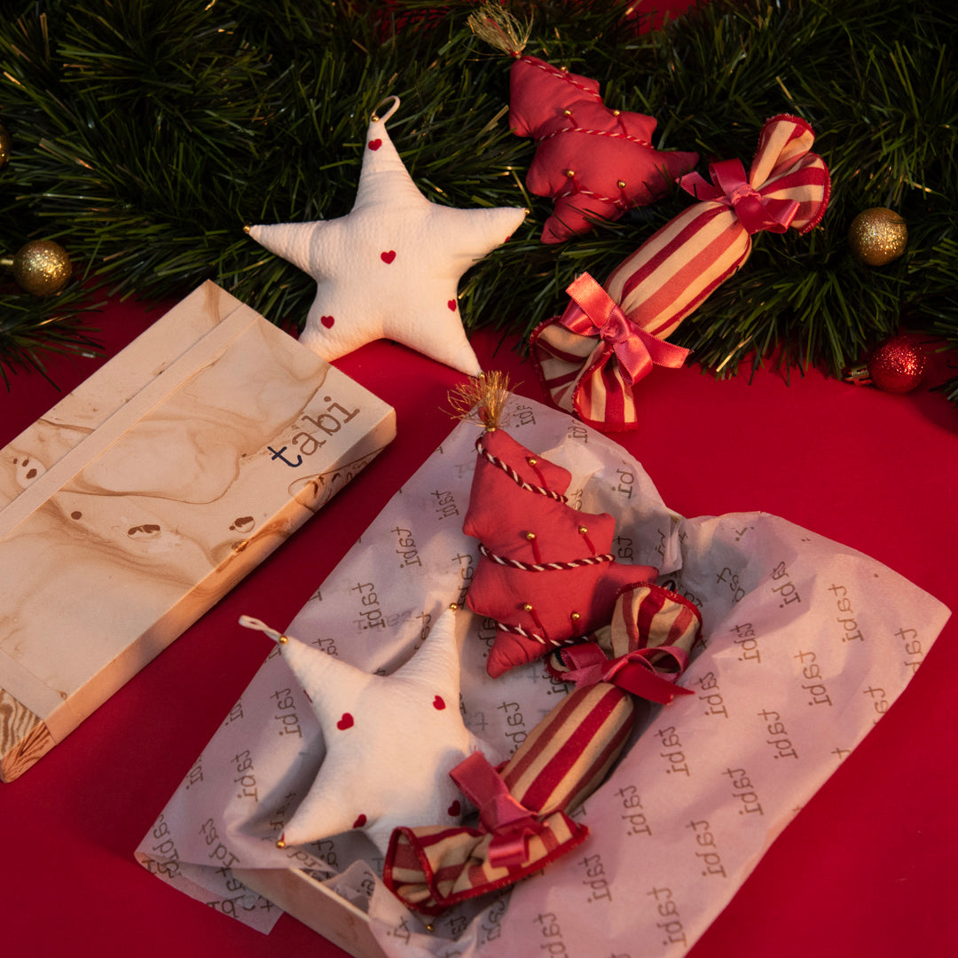 Christmas-themed decorations including stars and candy canes on a red surface with greenery.