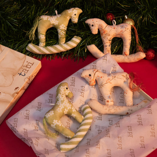 Decorative fabric animals on a red surface with a textured paper background