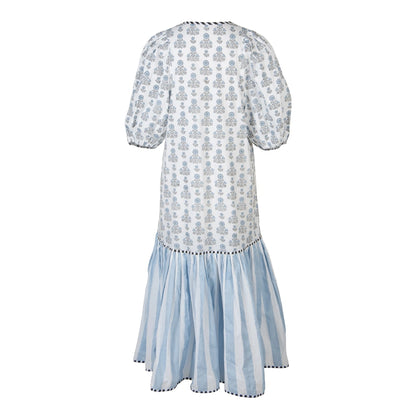 A white and light blue patterned dress with puff sleeves and a tiered skirt, shown from the back on a plain white background.