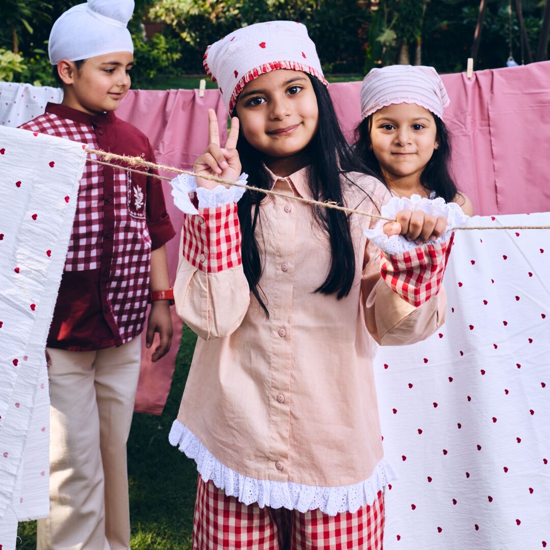 girl wearing Beige shirt with red and white checkered cuffs and lace detailings at the hem and cuff