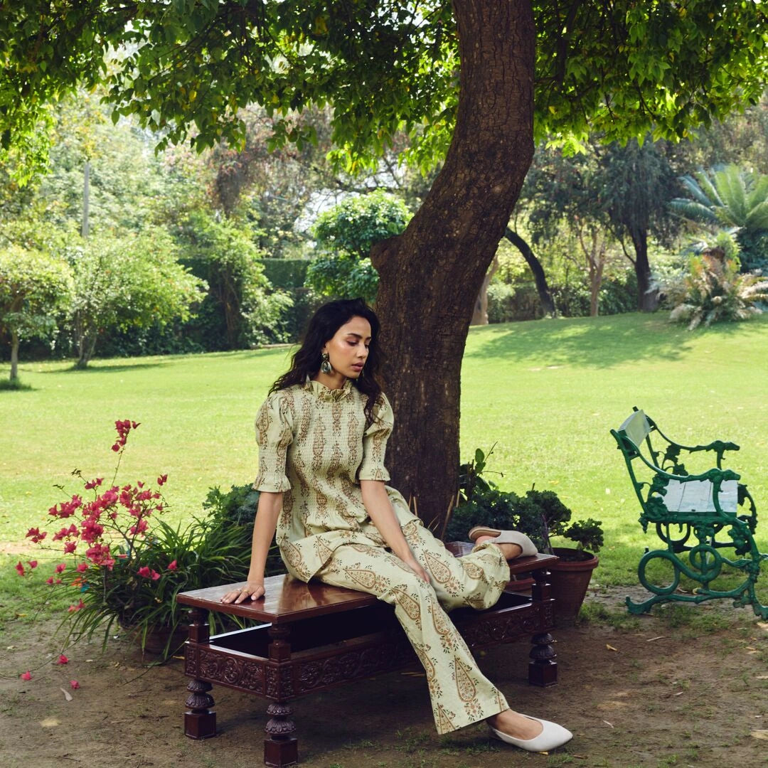 Woman sitting on a wooden bench under a tree in a park