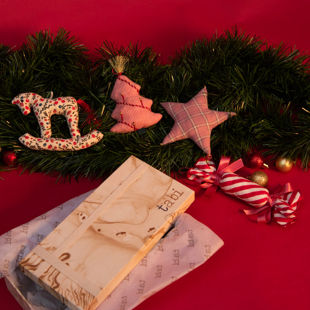 Decorative Christmas scene with a book, candy, and ornaments on a red background