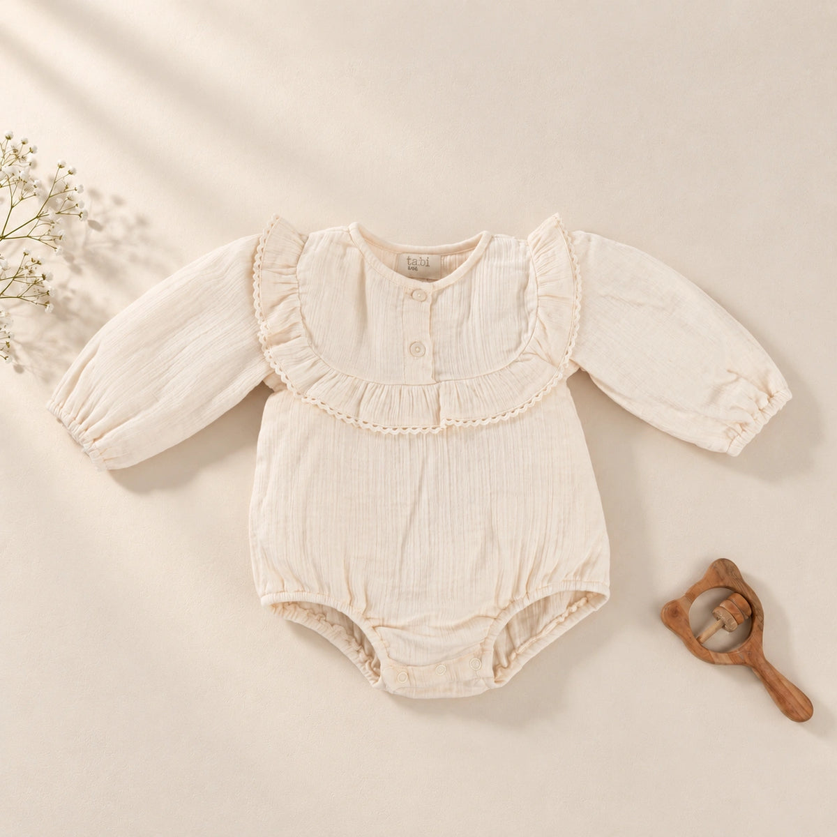 Beige bodysuit with delicate lace detailing and full sleeves.