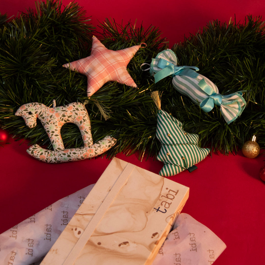 Decorative Christmas wreath with ornaments on a red surface