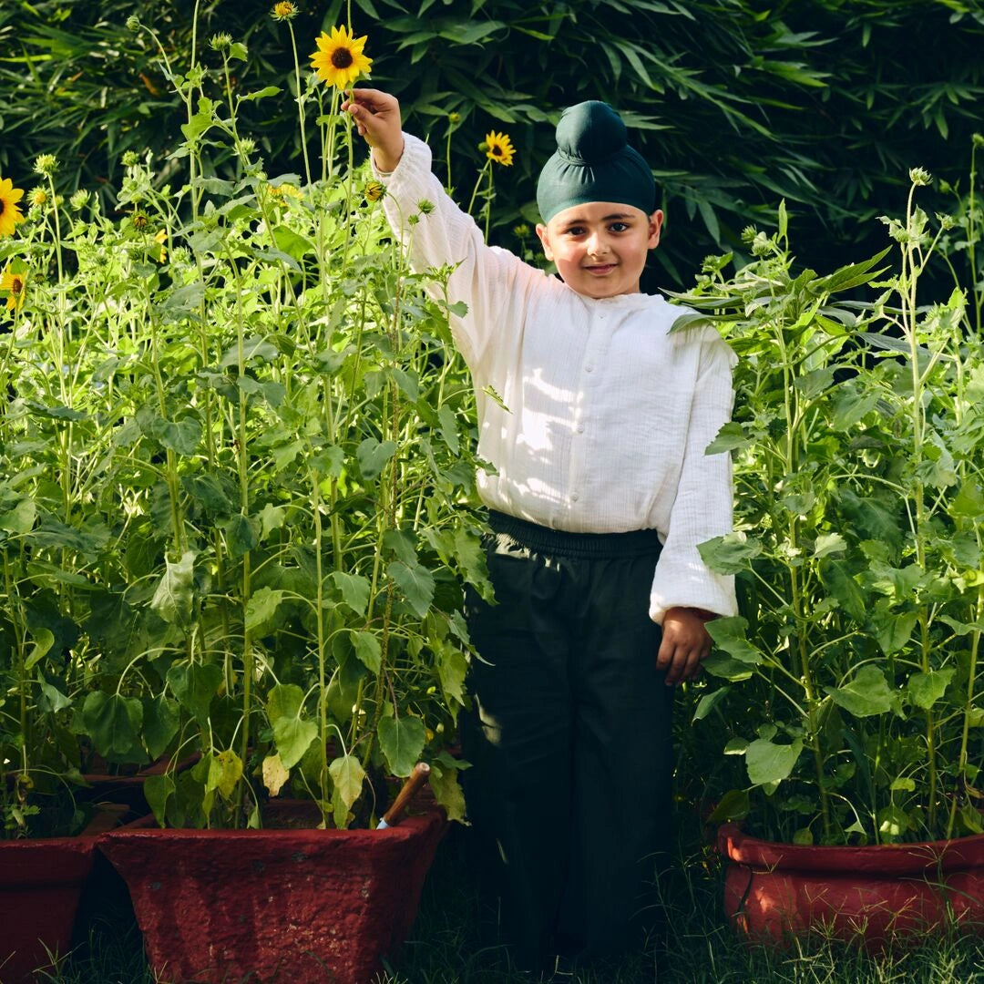 Child in a garden with sunflowers and greenery