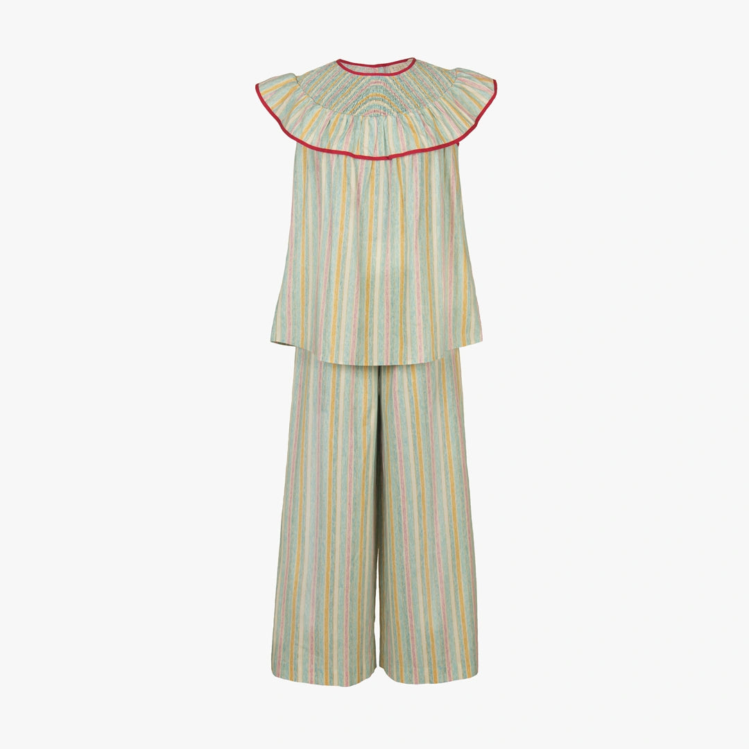 A two-piece children's outfit featuring a sleeveless top with a wide pleated ruffle collar and matching wide-leg pants, both in a light sage green fabric with vertical pastel stripes of yellow, blue, and orange, finished with a red inner collar trim.