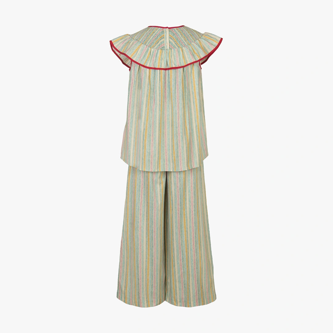 A two-piece children's outfit featuring a sleeveless top with a wide ruffled collar trimmed in red, paired with matching wide-leg pants, both in a pastel multicolor striped pattern on a light gray background.